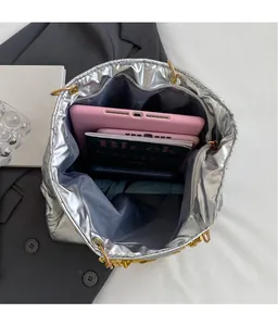 Top view of spacious interior in silver padded tote bag with gold chain handles