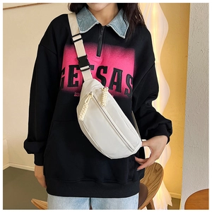 Close-up of white crossbody fanny pack showing fabric texture and adjustable strap