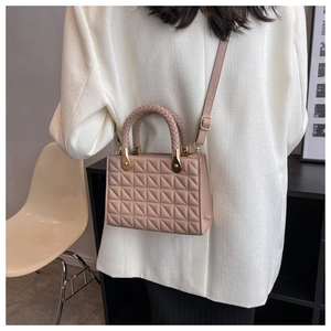 Detail of light apricot quilted crossbody bag with woven handle and gold-tone hardware