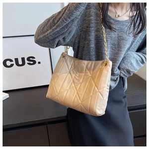 Detailed close-up of beige quilted tote bag with diamond stitching and gold chain strap