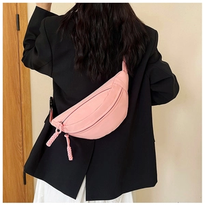 Pink nylon belt bag detail featuring woven rope zipper pulls and a minimalist design
