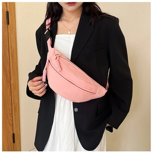 Detailed shot of pink crescent crossbody bag with adjustable strap and braided zipper