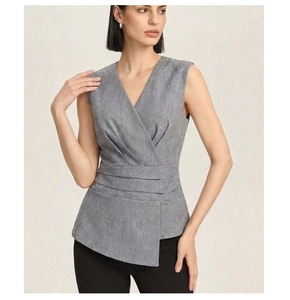 Detailed view of grey sleeveless V-neck top featuring waist pleats and asymmetric hem