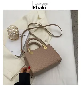 Detail view of khaki crossbody bag with quilted texture and woven top handle detail