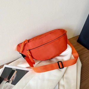 Detail of bright orange nylon waist bag with double zippers and adjustable strap