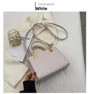 Detail of off-white quilted crossbody bag with gold hardware and woven handles