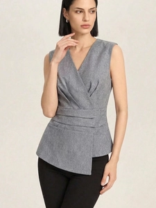 Detailed view of the gray sleeveless V-neck top with wrap design and peplum waist texture