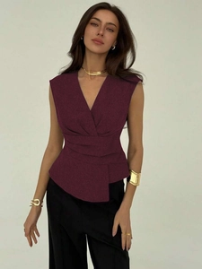 Detail of dark red sleeveless V-neck top with wrap-waist design and peplum hem