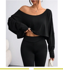 Dettaglio del top corto nero monospalla a maniche lunghe in maglia a coste