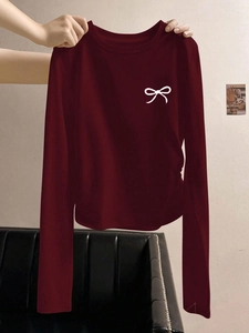 Dettaglio maglia bordeaux a maniche lunghe con stampa di fiocco bianco sul petto