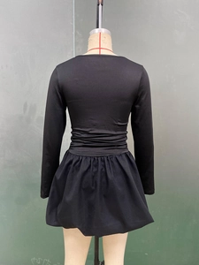 Détails de la robe noire à manches longues avec taille froncée et jupe plissée évasée