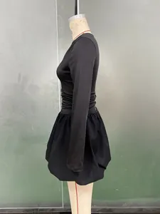 Détails d'une robe noire à manches longues avec taille plissée et jupe boule