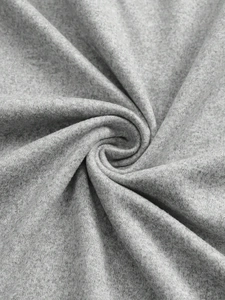 Dettaglio macro del tessuto a maglia grigio che mostra la morbida miscela di cotone