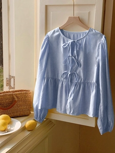 Chemise à rayures bleues et blanches avec nœuds frontaux et détails de basque à la taille