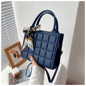 Quilted navy blue tote bag with top handles, crossbody strap and decorative silk scarf