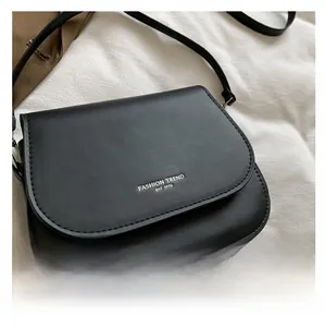 Détail du sac selle en cuir PU noir avec logo argenté imprimé Fashion Trend