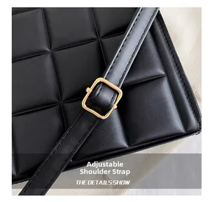 Detail of adjustable leather strap with gold metal buckle on quilted tote bag