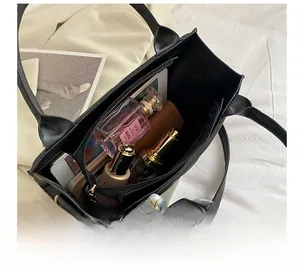 Detail showing spacious interior capacity of black leather tote bag with gold hardware