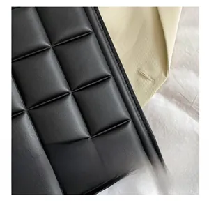 Detailed close-up of premium black woven faux leather texture and fine stitching work