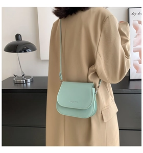 Détail du sac bandoulière en cuir vert menthe avec logo et bandoulière réglable