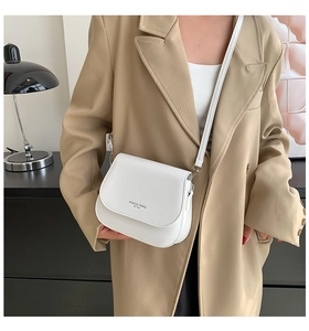 Gros plan sur le sac à bandoulière blanc minimaliste avec détail du texte en argent