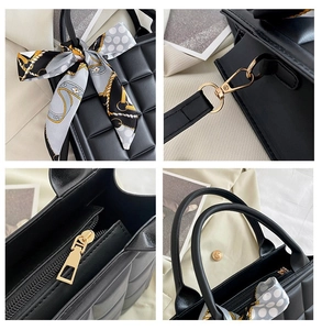 Macro view of black quilted tote bag texture with gold hardware and silk scarf detail