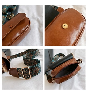 Detail view of brown PU leather saddle bag with bohemian printed wide shoulder strap