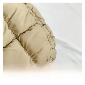 Macro view of light beige quilted fabric with square padded stitching and satin finish