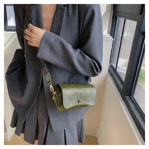 Detail of dark green PU saddle bag with patterned wide ethnic shoulder strap
