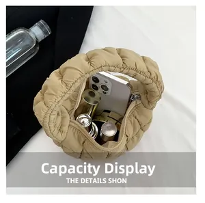 Internal view of beige quilted cloud bag showing phone and cosmetics storage capacity