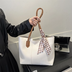 Minimalist beige tote bag with brown handles and checkered silk scarf accessory
