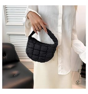 Close-up of black quilted cloud bag with puffy texture and integrated handle