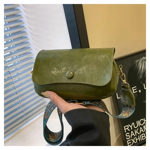 Detail of avocado green PU leather crossbody bag with bohemian patterned wide strap