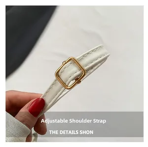 Detail of white leather adjustable shoulder strap with gold metal buckle and fine stitching