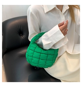 Macro detail of bright green quilted cloud bag with padded texture and puffy handle