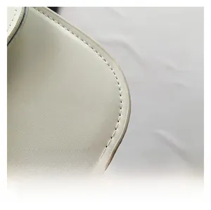 Detail of premium white lychee texture leather and fine stitching on saddle bag