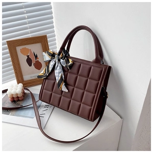 Detail of dark brown checkered tote bag featuring a decorative silk scarf on the handle