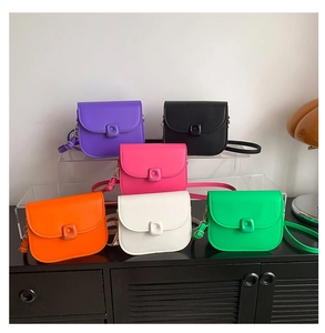 Group display of multiple colorful matte leather saddle bags with square buckle detail
