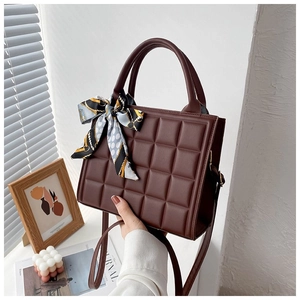 Detail of chocolate brown quilted tote bag with elegant silk scarf and detachable strap
