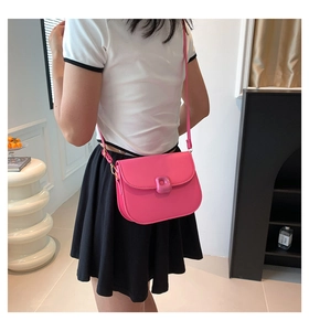 Detail view of pink saddle bag with adjustable strap worn as a stylish crossbody purse