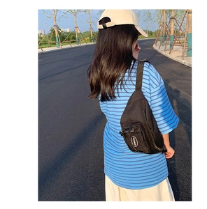 Détail de la bandoulière réglable et boucle en plastique du sac de poitrine noir