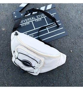Détail d'un sac banane blanc en tissu Oxford avec cordons élastiques noirs et boucle