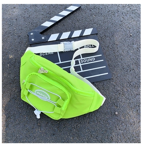 Détail du sac banane en tissu oxford vert fluo avec sangle réglable sur le bitume