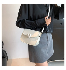 Detail of white PU leather saddle bag with square buckle worn as a shoulder bag