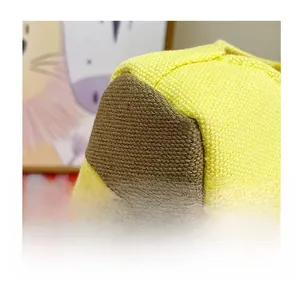 Detailed macro view of yellow canvas handbag featuring thick brown stitching and texture