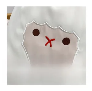 Gros plan d'une broderie de mouton mignon sur le tissu en toile blanche du sac à dos