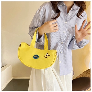 Detail of yellow canvas handbag with KeepKind embroidery and cute smiley face design