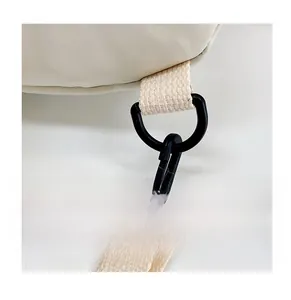 Détail du crochet pivotant noir et de l'anneau en D sur un sac à bandoulière en nylon