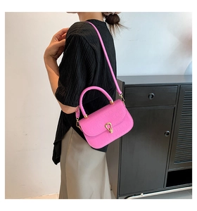 Dettaglio borsa rosa acceso trama coccodrillo con chiusura metallica dorata a goccia