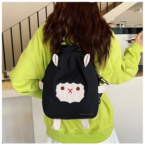 Détail arrière d'un sac à dos mouton noir mignon porté avec un sweat-shirt jaune vif